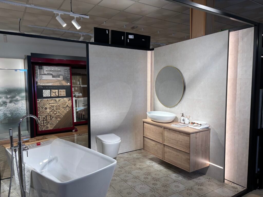 Exposición de muebles de baño de Grupo AJF con bañera exenta, mueble suspendido y espejo redondo